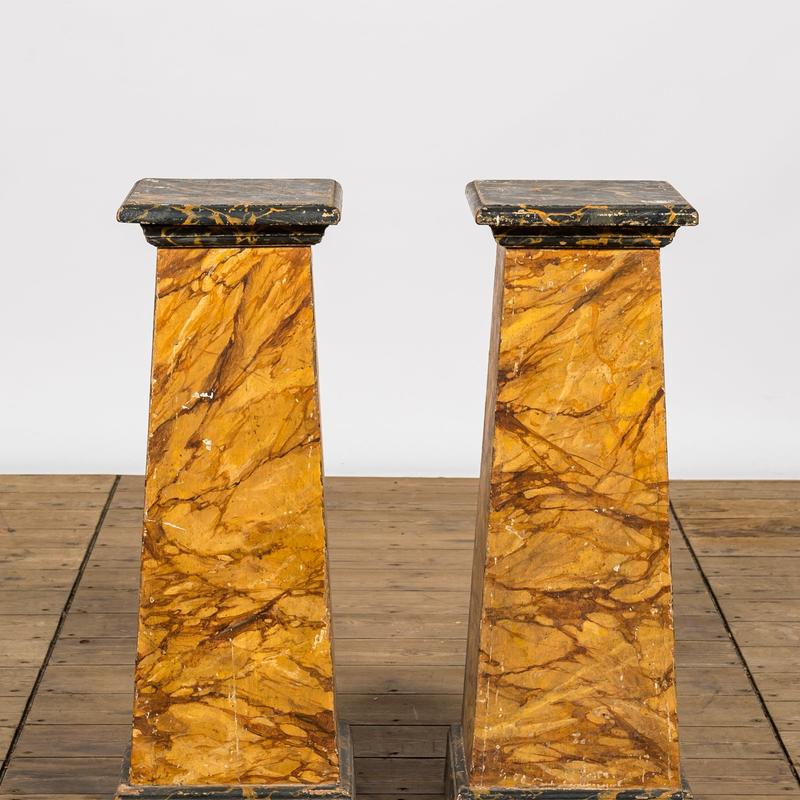 A pair of faux-marbre wooden pedestals 