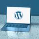 Laptop met WordPress-logo op het scherm, getoond op een reflecterende ondergrond met blauwe tint