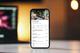 Smartphone met restaurantmenu op een online bezorgapp getoond tegen een warme, onscherpe achtergrond met bokeh-effect