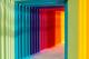 Tunnel met regenboogkleurige panelen die een optisch effect creëren, van groen via blauw en paars naar rood en geel