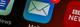Close-up van een e-mail app icoon met 2 ongelezen berichten, getoond op een donker smartphonescherm naast andere apps