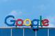 Het kleurrijke Google-logo bovenop een kantoorgebouw tegen een blauwe lucht met enkele witte wolken.