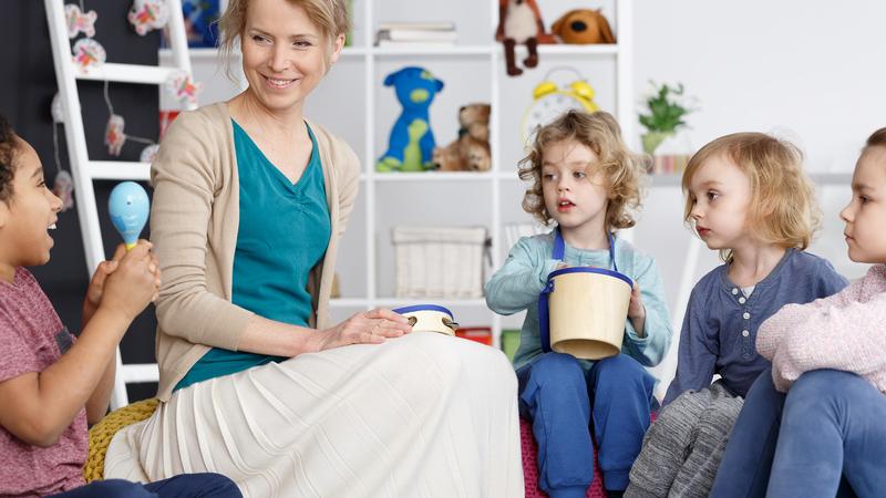 Pedagogisch professional maakt muziek met de kinderen