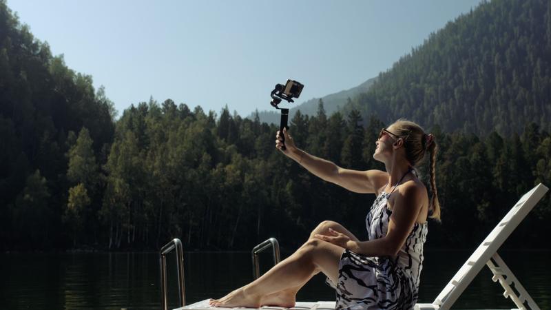 Vrouw met smartphone gimbal Voorbeeld smartphone gimbal