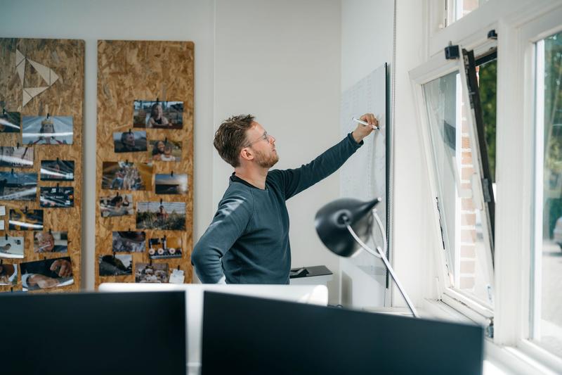 Man schrijft iets op bord Man is bezig met strategie en planning